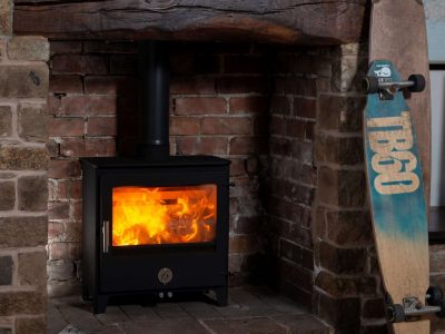 Chilli Penguin Woody wood-burning stove with heat-resistant glass ceramic door panel, fire on.