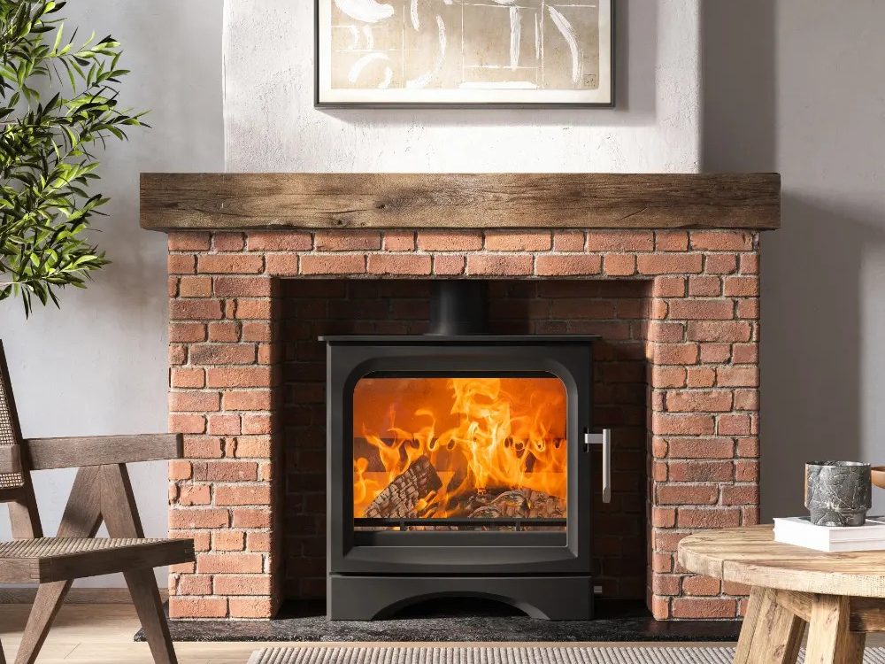 Ecosy Signature 5 Wide wood-burning stove with heat-resistant glass ceramic door panel, fire on.
