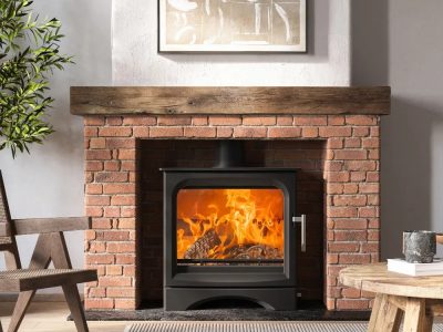 Ecosy Signature 5 Wide wood-burning stove with heat-resistant glass ceramic door panel, fire on.