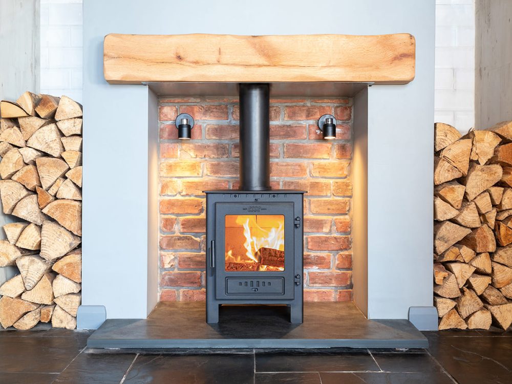 ESSE 1 wood-burning stove with heat-resistant glass ceramic square door panel, fire on.