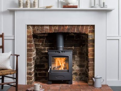 Hamlet Solution 5 freestanding wood-burning stove with heat-resistant glass ceramic door panel, fire on.