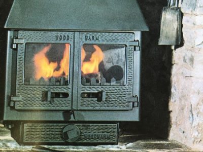 Woodwarm Fireblaze Model No7 7kW wood-burning stove with heat-resistant glass ceramic door panels, fire on.